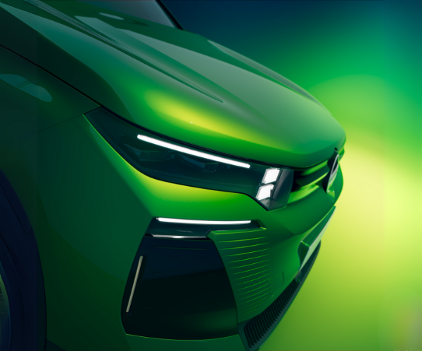 Close-up of a green car's front showing LED headlights and grille.