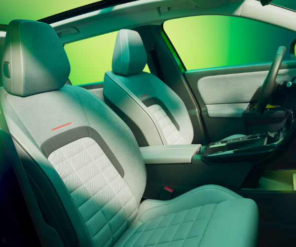 Front seats of a modern car interior with green accents and a visible steering wheel.