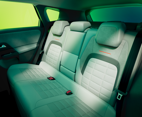 Back seat of a car with grey upholstery and visible seat belts.