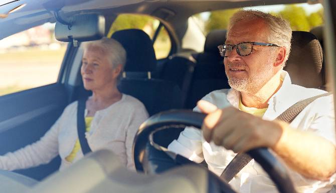 Pensioner couple driving a car